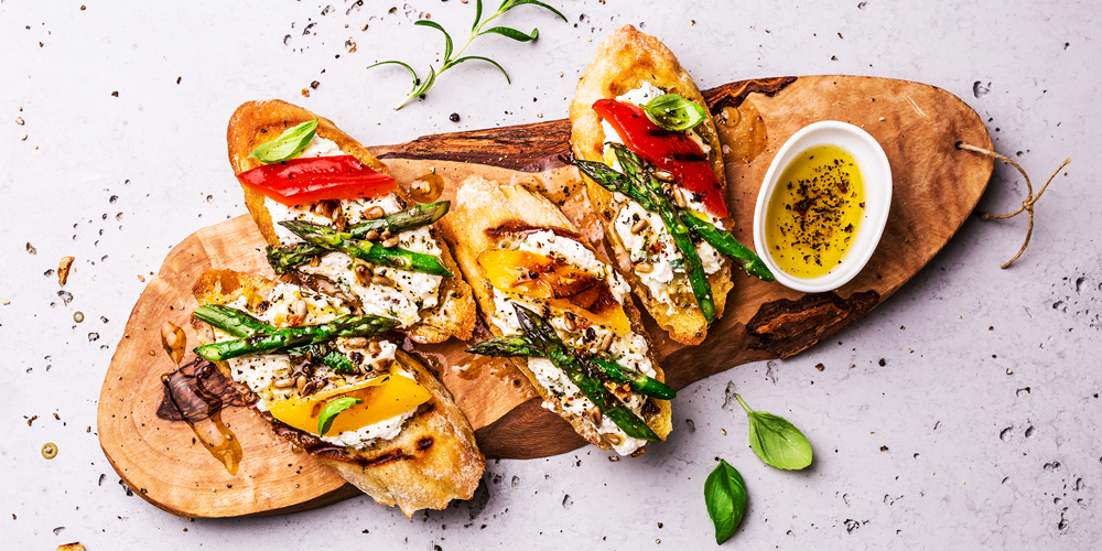 4 Bruschetta burrata asperges sur une planche de bois / 4 Bruschetta burrata asparagus on a wooden board