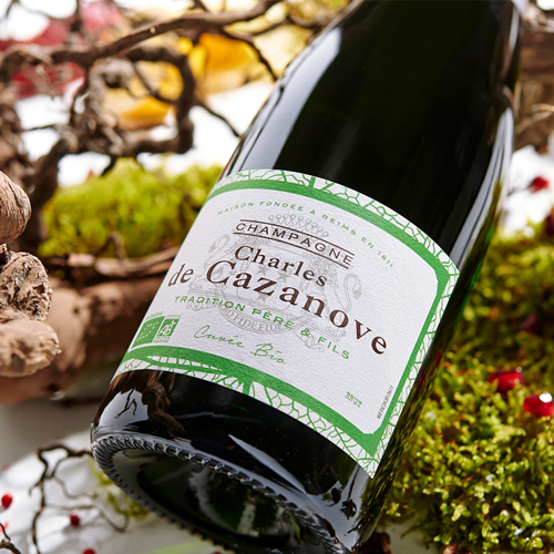 Zoom sur l’étiquette de la cuvée Bio, serments de vignes et mousse en fond / Zoom on the label of the Cuvée Bio, oaths of vines and mousse in the background