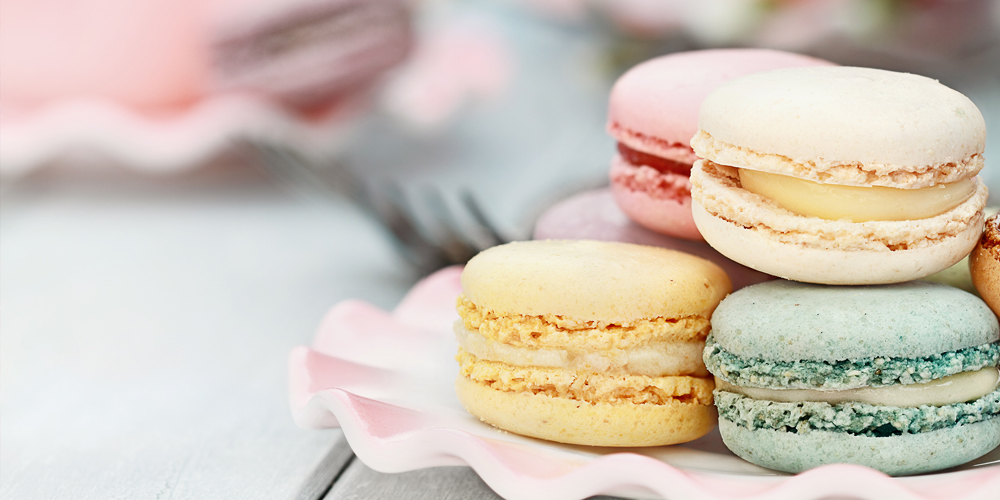 Quatre Macarons de couleur différente dans une assiette / Four different-coloured macaroons on a plate