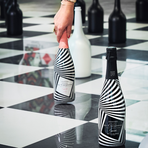 jeu de dames géant, une main saisit une bouteille de Senses Rosé qui apparaît comme un pion / A giant draughts game, with one hand grasping a bottle of Senses Rosé, which appears as a pawn.